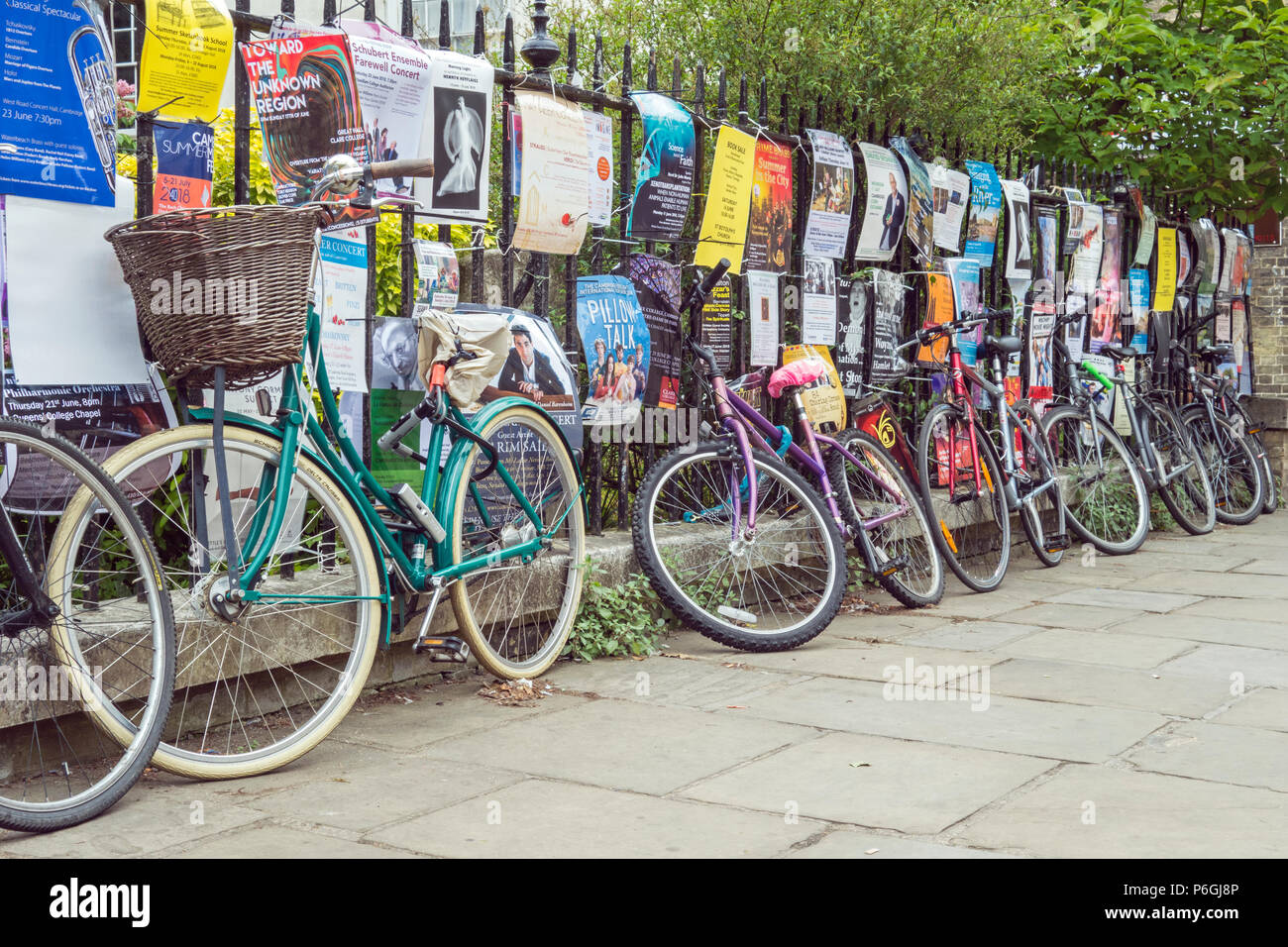 Student bicycles and fliers on railings, Cambridge, Cambridgeshire, England Stock Photo