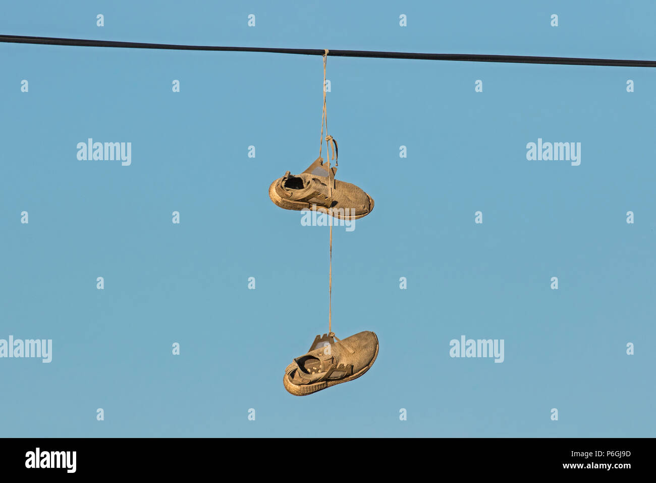 Pair of training shoes hanging over a telephone wire, Cambridgeshire Stock Photo