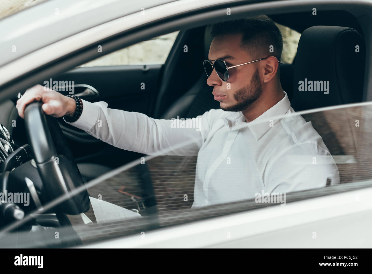 Handsome Young Man Sitting in the Luxury Vehicle Stock Photo