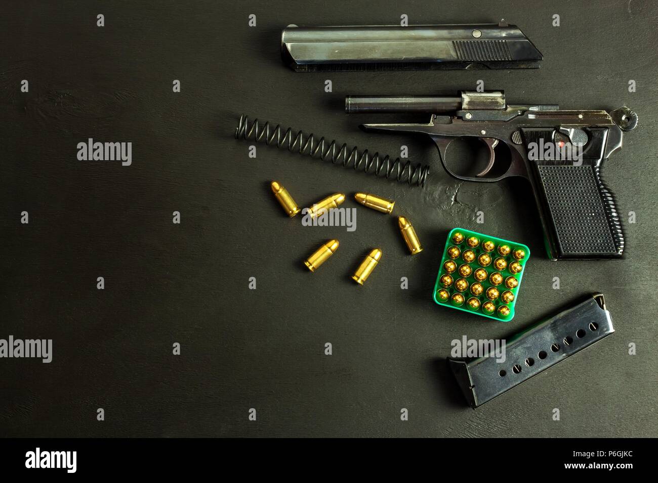Disassembled pistol on black background. Separated pistol parts. Gun