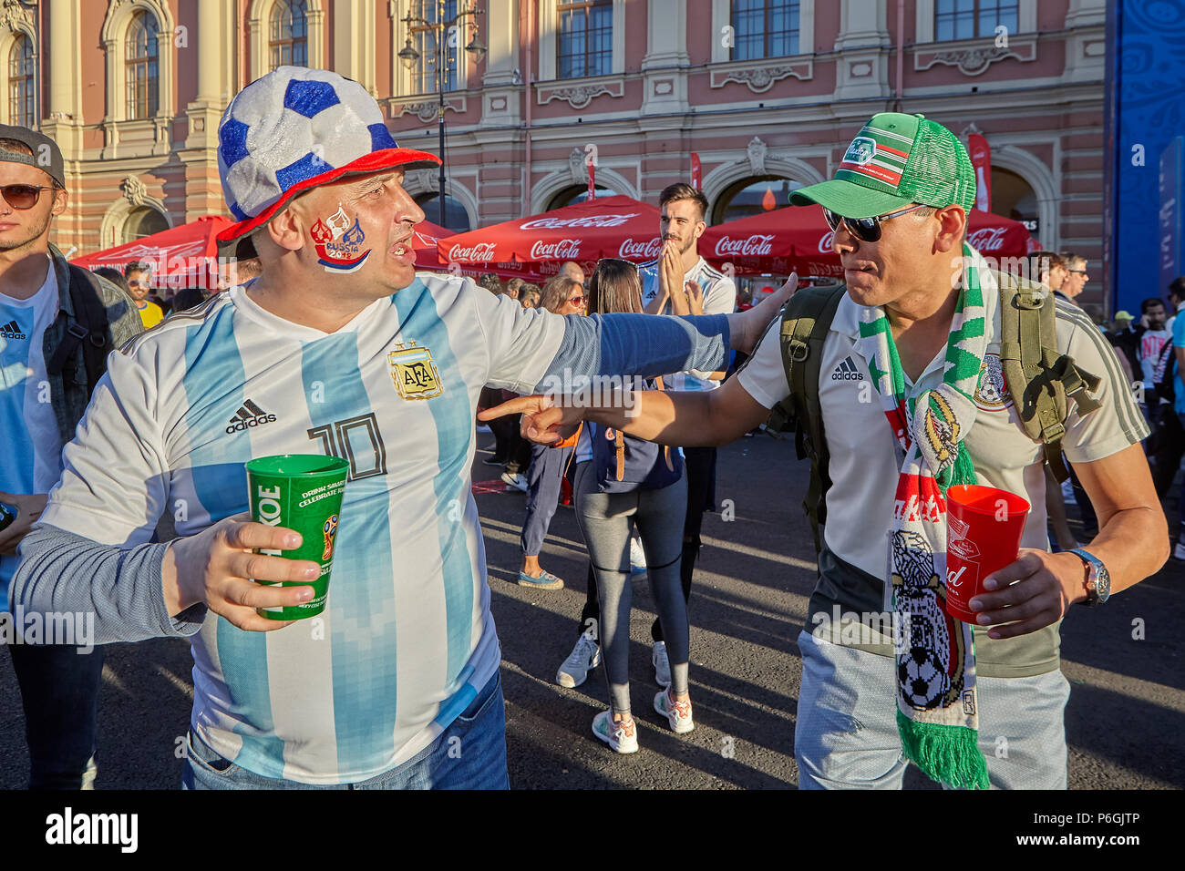 St. Petersburg, Russia - June 25, 2018: Russian fan of  soccer with foolish hat meet supporter Mexico national football team in fan zone FIFA World Cu Stock Photo