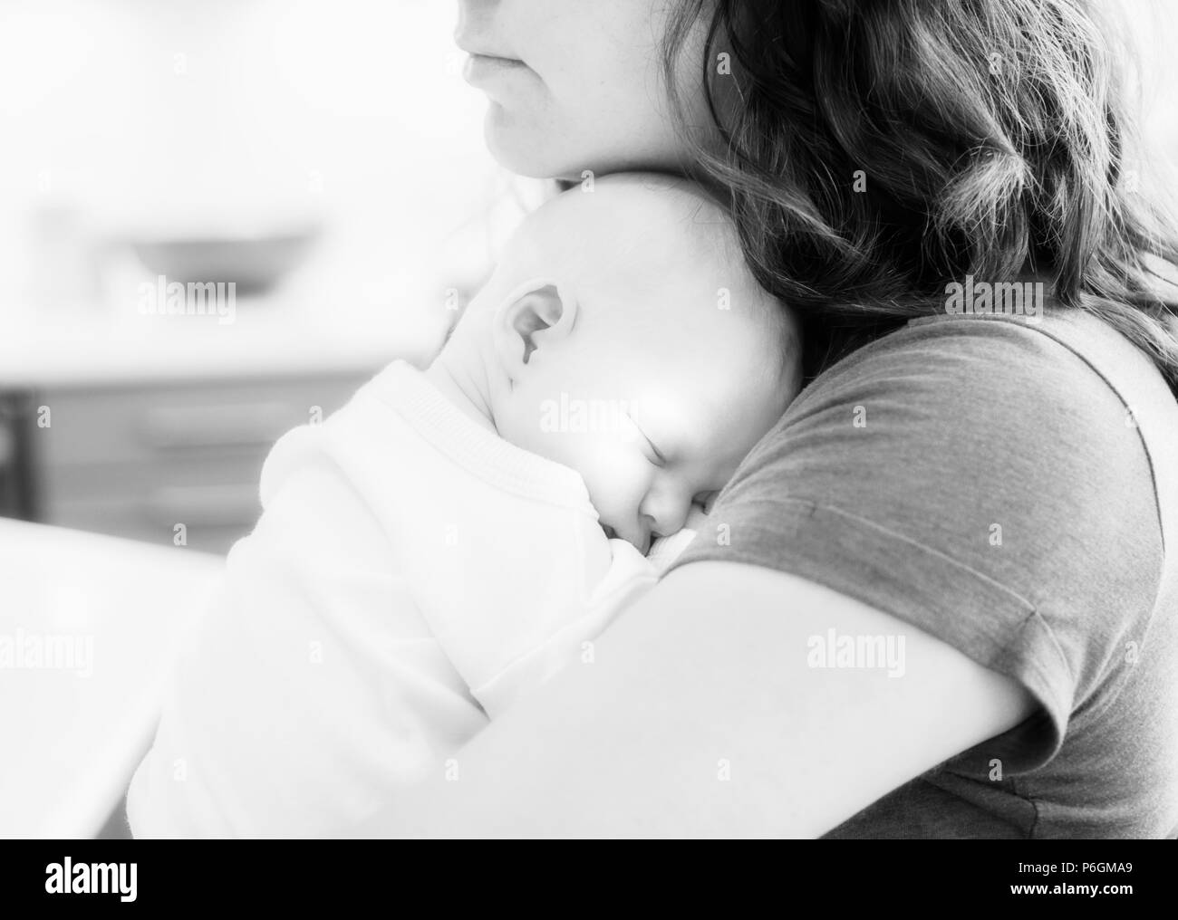 Affectionate mom cuddling newborn hires stock photography and images