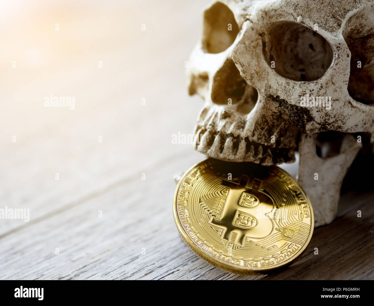 Close up of Skull biting Golden bitcoin on wooden table. The concept of  investment and Fluctuation of bitcoin and cryptocurrency. The feeling of  disap Stock Photo - Alamy