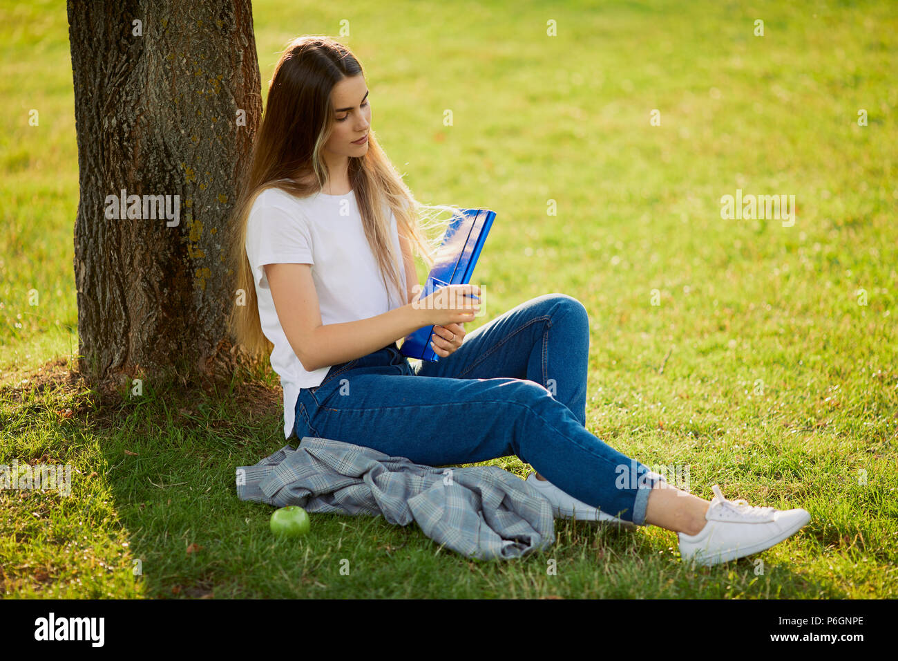 Pretty girl with her book in park background, sunset Stock Photo - Alamy