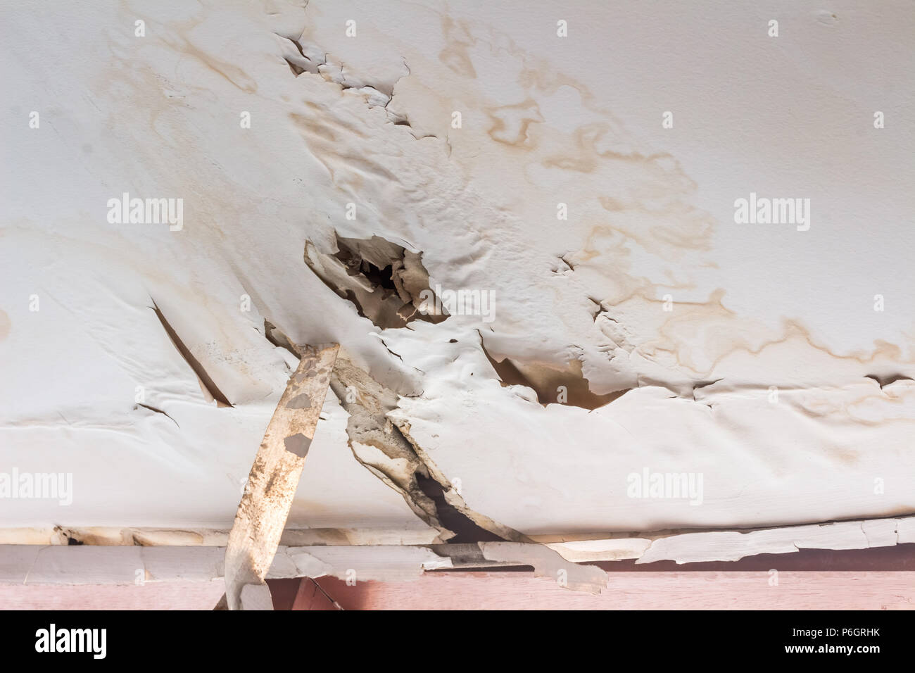 Damaged ceiling caused by leaking water. Stock Photo