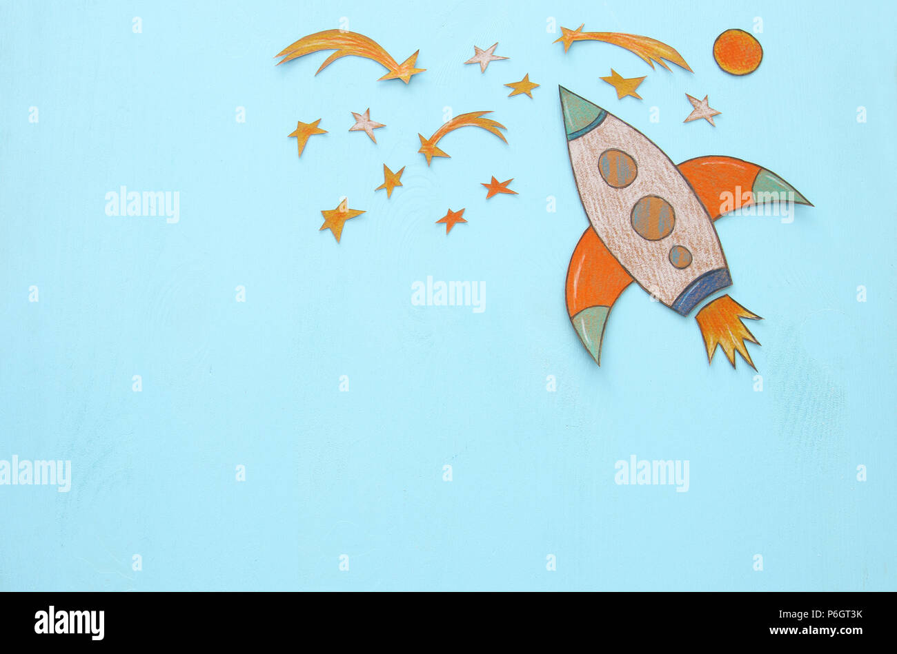 Rocket cut from paper and painted over wooden blue background Stock ...