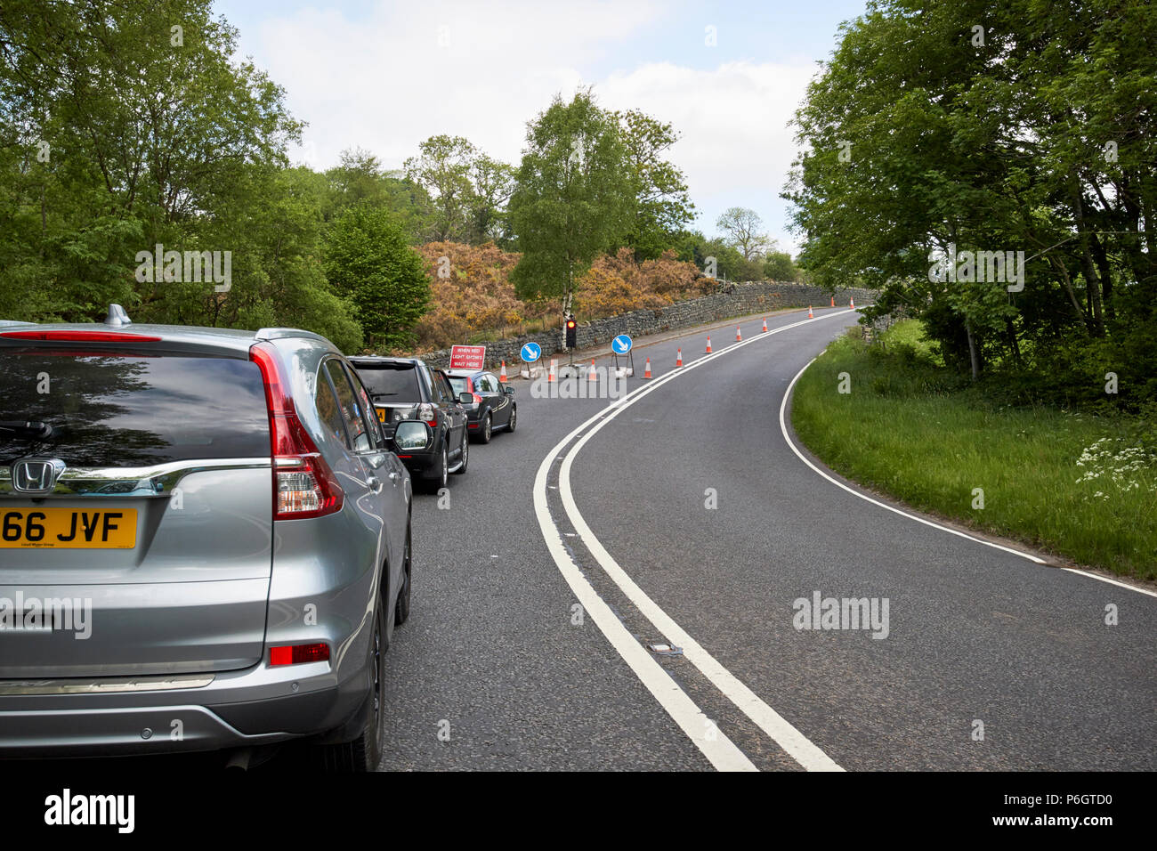 cars waiting at temporary lights at roadworks on a no overtaking section of the a591  near keswick in the lake district cumbria england uk Stock Photo