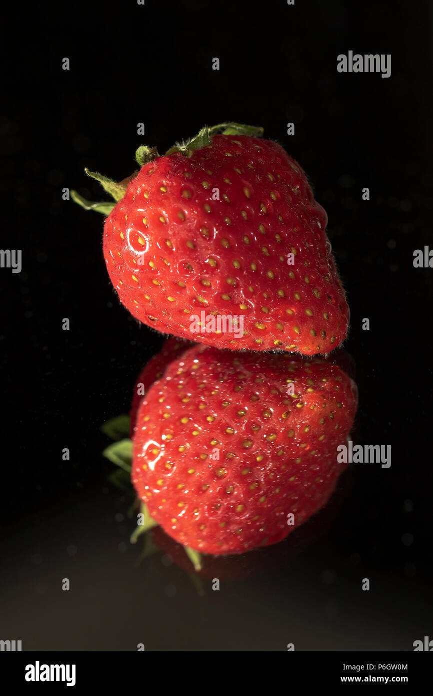 A strawberry and his reflection in the darkness Stock Photo - Alamy