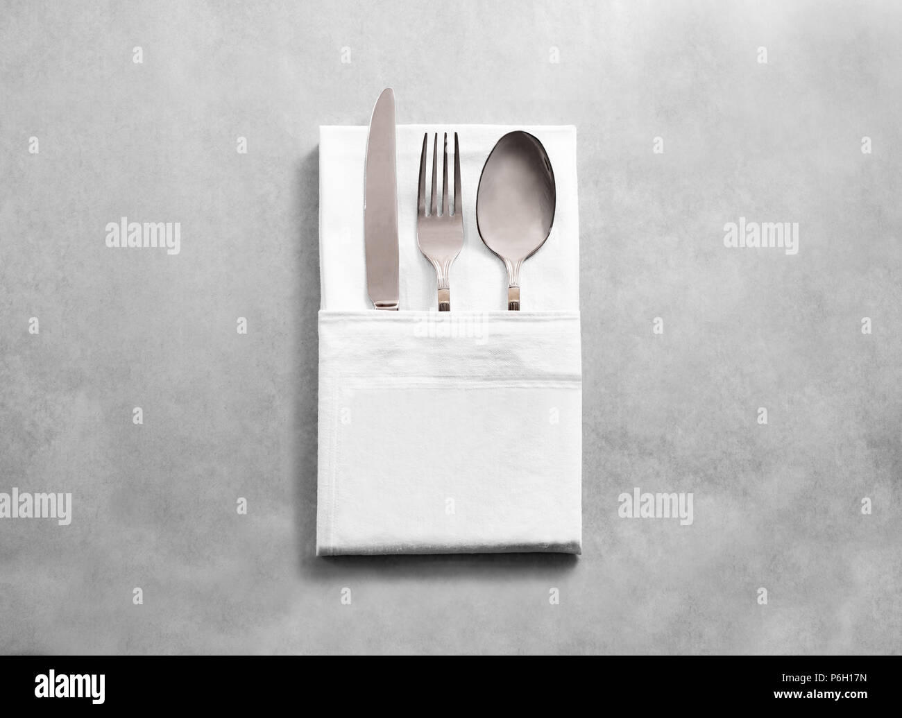 Blank white restaurant cloth napkin mockup with silver cutlery set, isolated. Knife fork and spoon in clear textile towel mock up template. Cafe branding identity clean napkin surface for logo design. Stock Photo