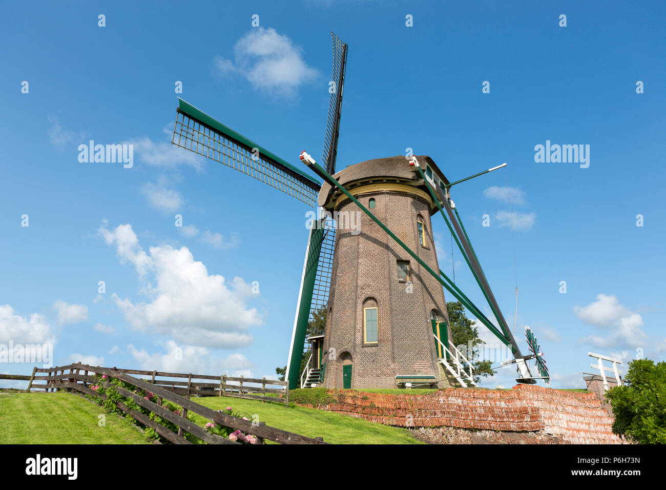 The dutch historic windmill 'Lijkermolen' on a dyke in the blue sky of the village of Rijpwetering. Stock Photo