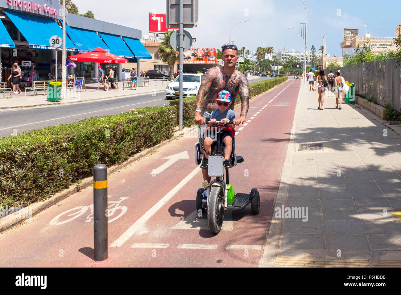 Tourist riding an electric trike with his on as passenger on the cycle tracks near Ayia Napa, Cyprus Stock Photo