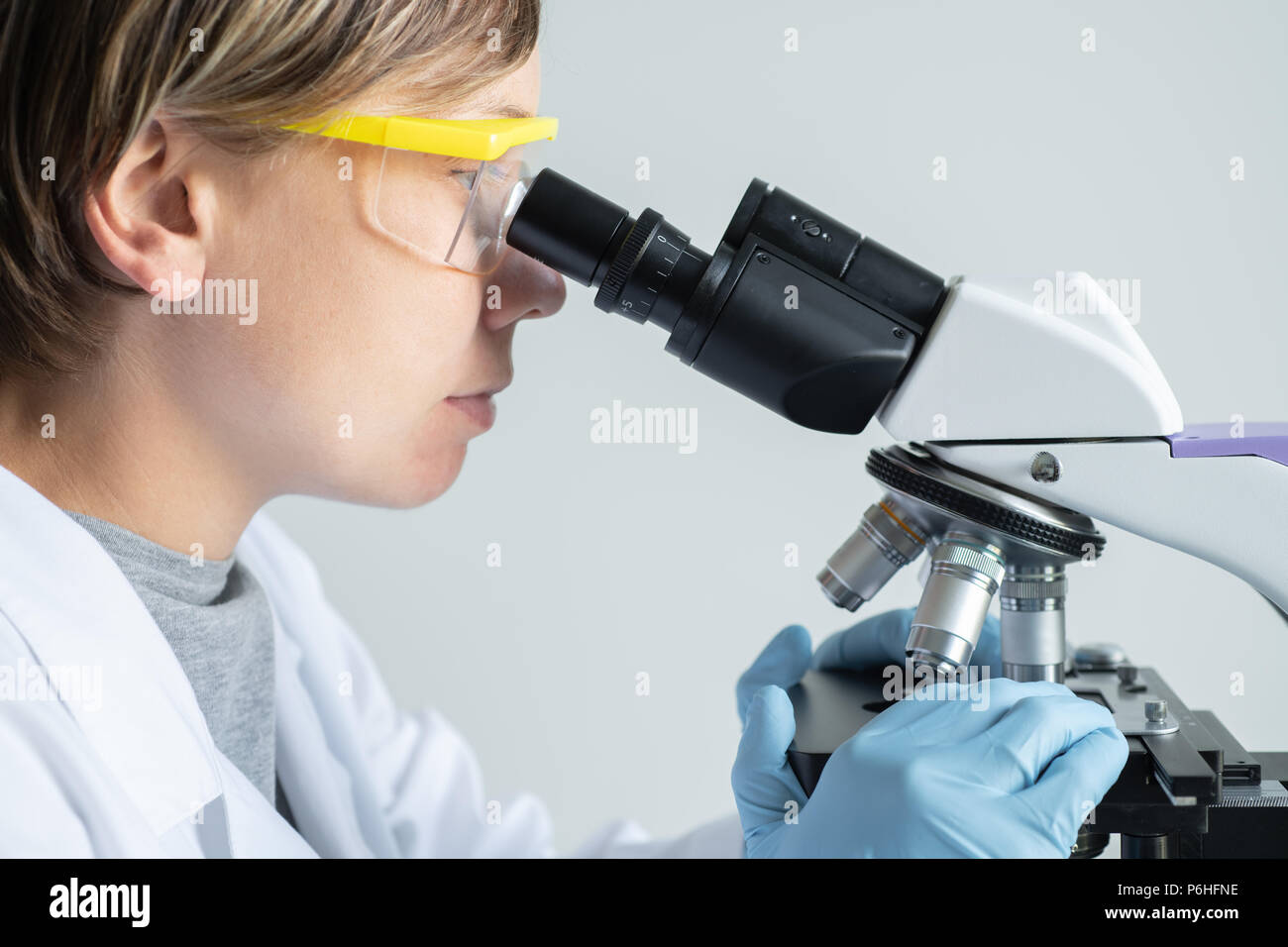 Scientist looking through a microscope Stock Photo Alamy