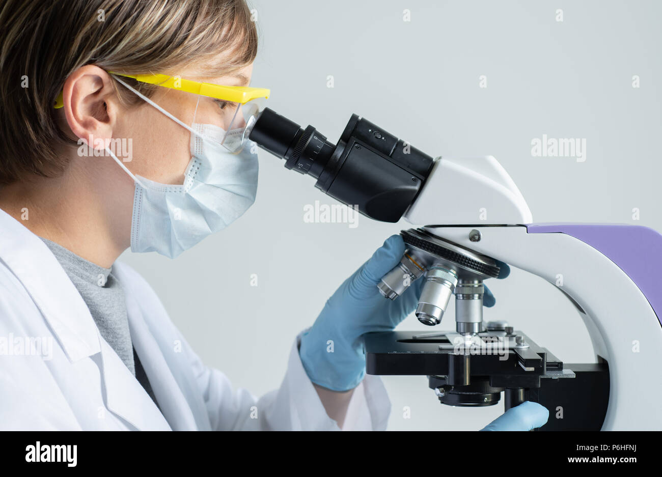 Scientist looking through a microscope Stock Photo Alamy