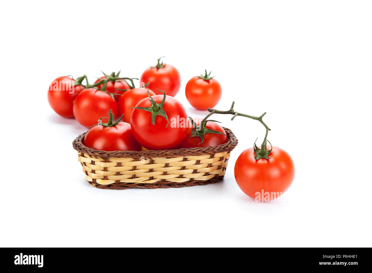 some red tomatoes in a small basket on a white background Stock Photo ...