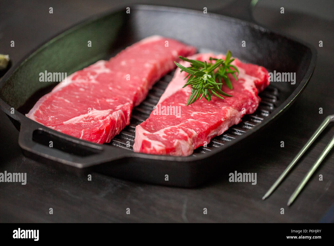 Raw New York strip steaks in cast iron frying pan Stock Photo Alamy