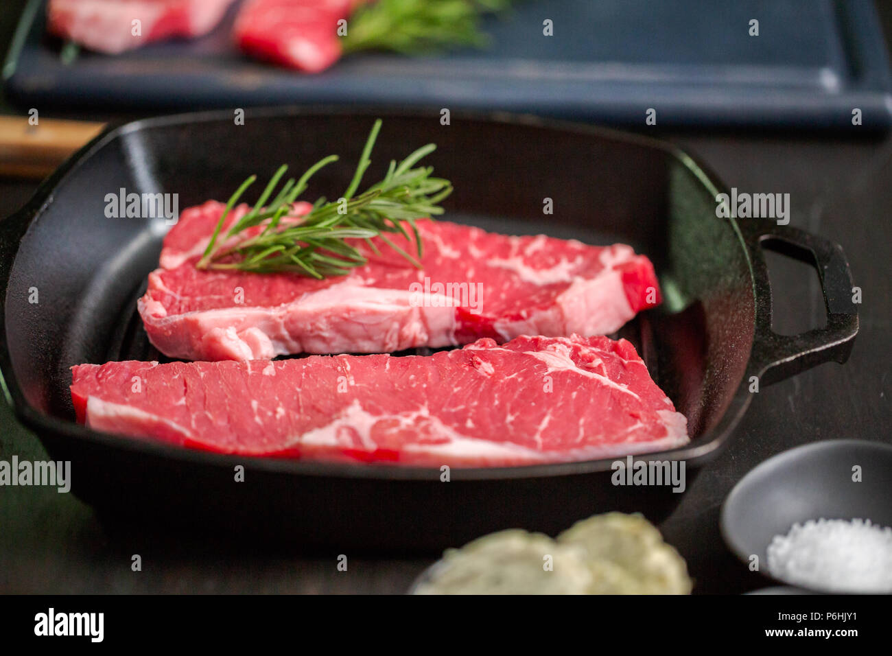 Raw New York strip steaks in cast iron frying pan Stock Photo Alamy