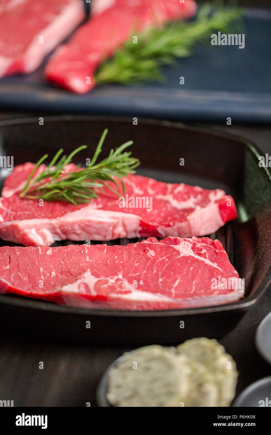 Raw New York strip steaks in cast iron frying pan Stock Photo Alamy