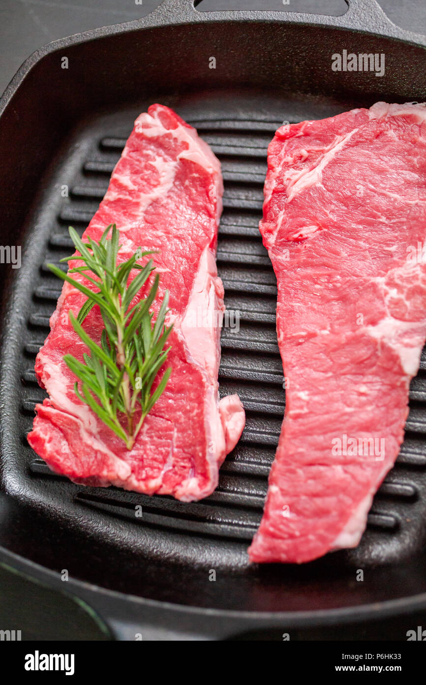 Raw New York strip steaks in cast iron frying pan Stock Photo Alamy