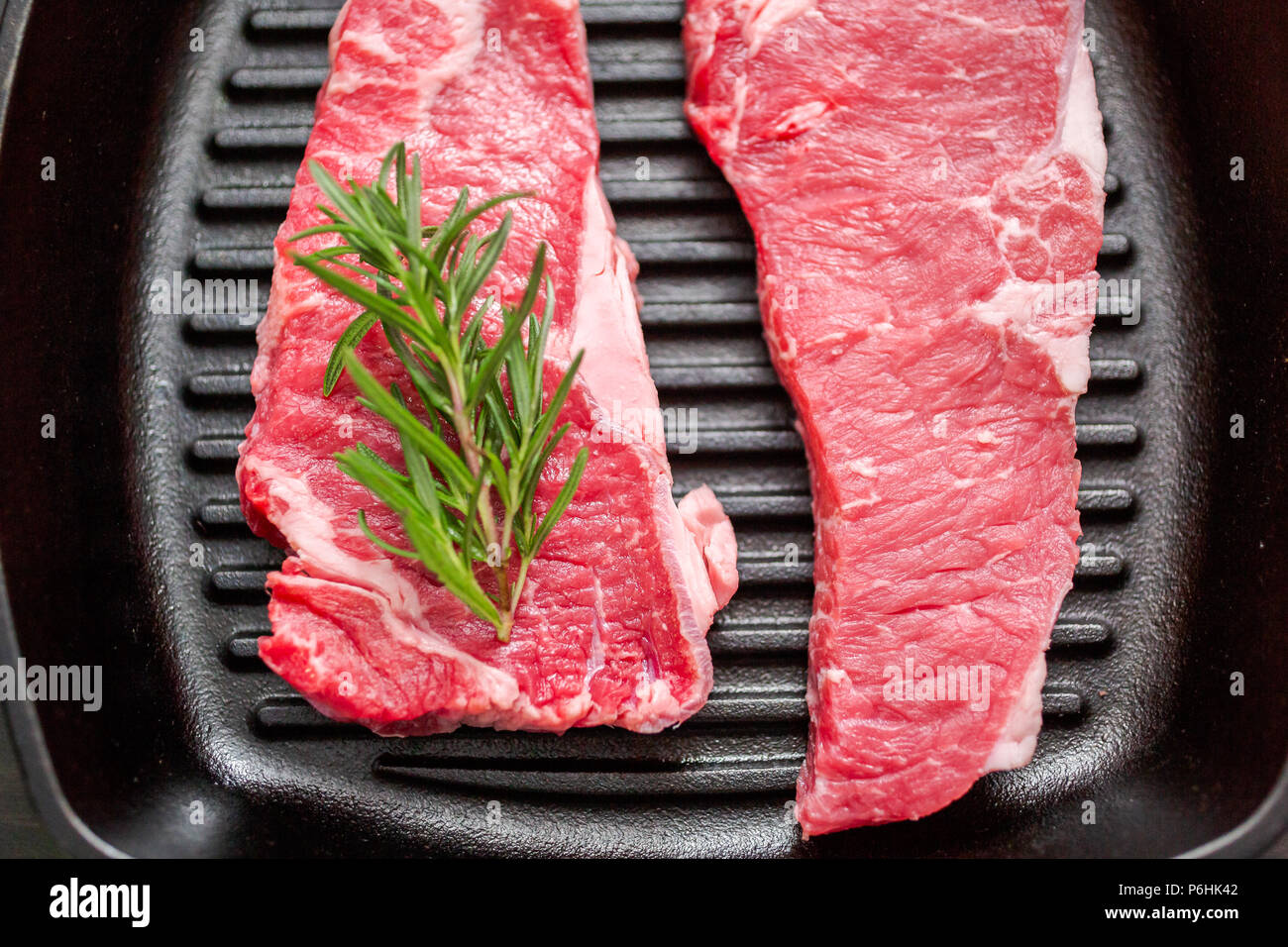 Raw New York strip steaks in cast iron frying pan Stock Photo Alamy