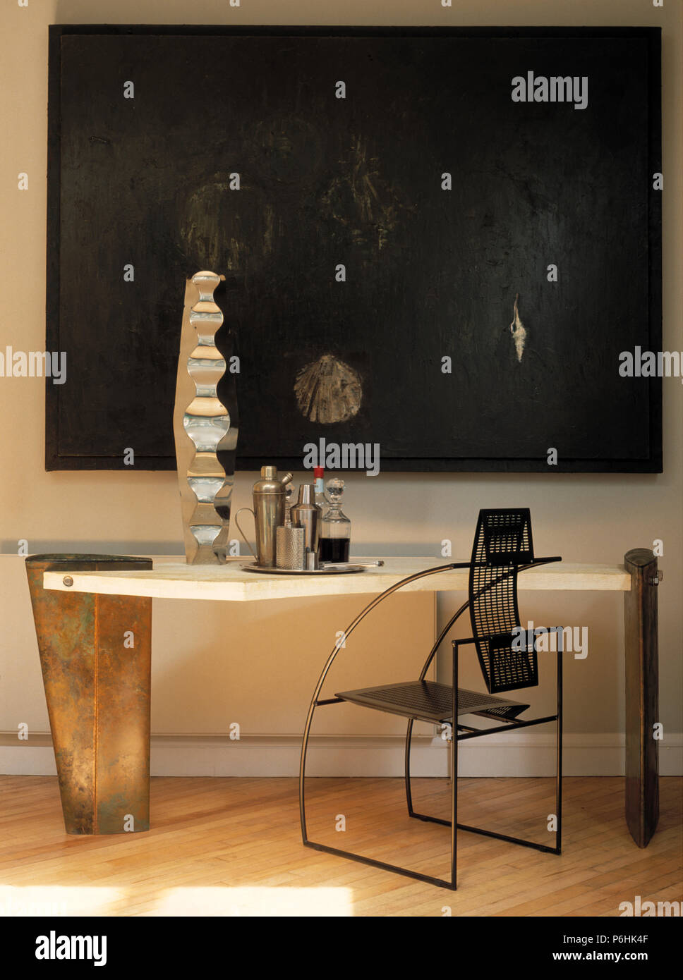 Large painting above modern console table and black metal chair Stock Photo Alamy