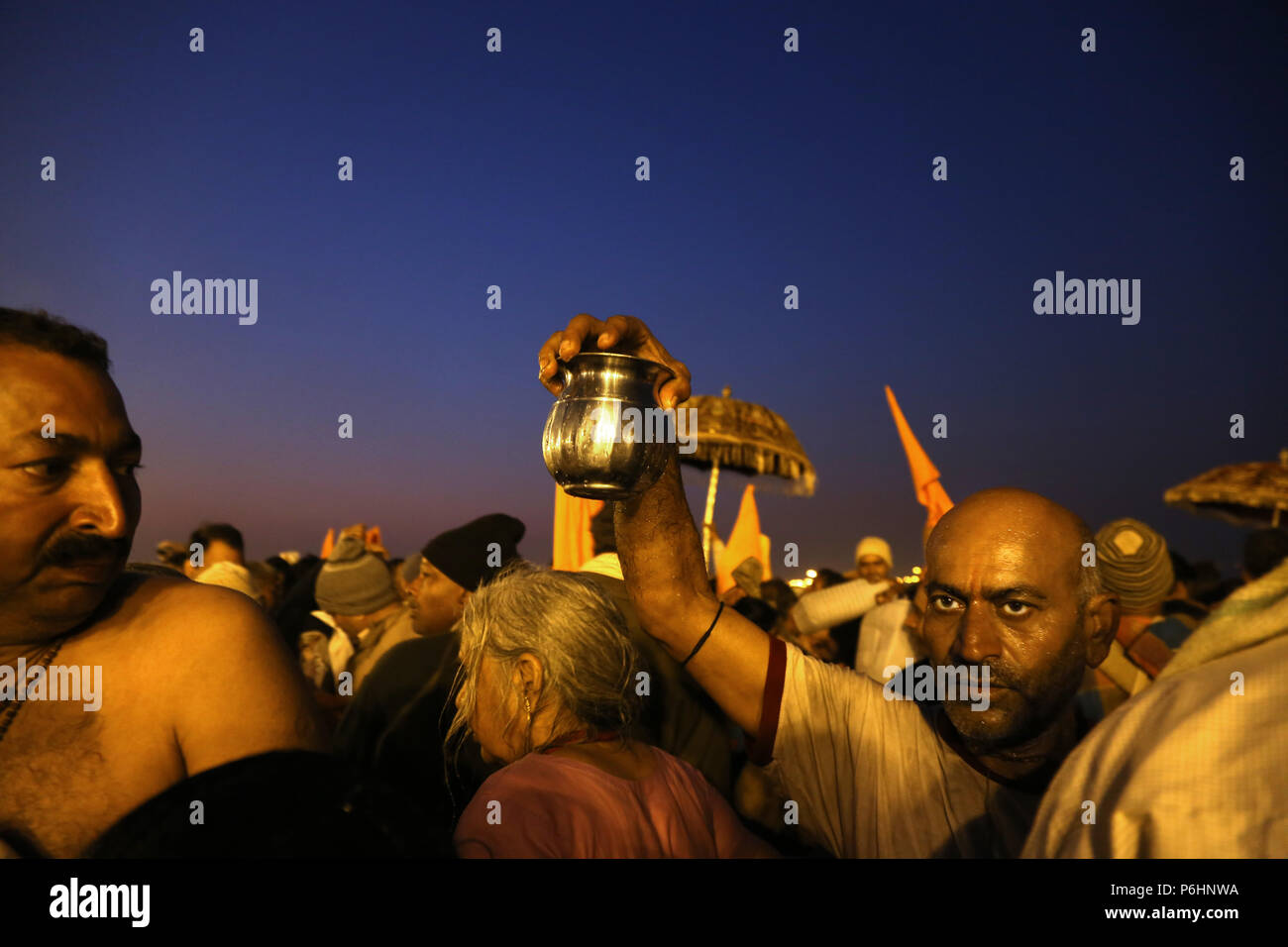 Man carries a jug with holy water from ganges river during Maha Kumbh mela 2013 in Allahabad , India Stock Photo