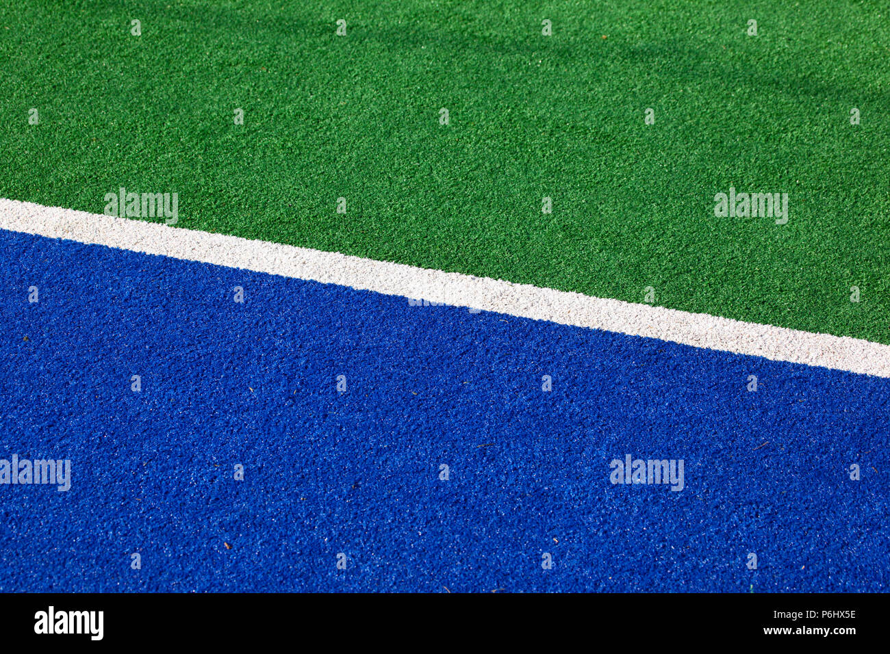Blue and green hockey field sideline for background use. Hockey is now often played on synthetic fields. Stock Photo