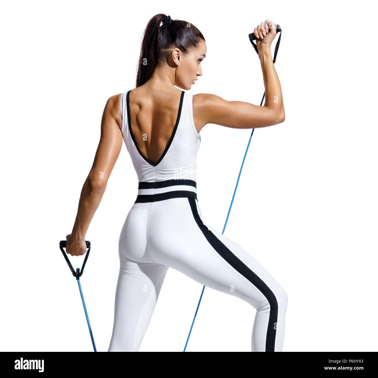 Sporty woman performs exercising with resistance band. Photo of fitness  model in fashionable sportswear isolated on white background. Strength and  mot Stock Photo - Alamy