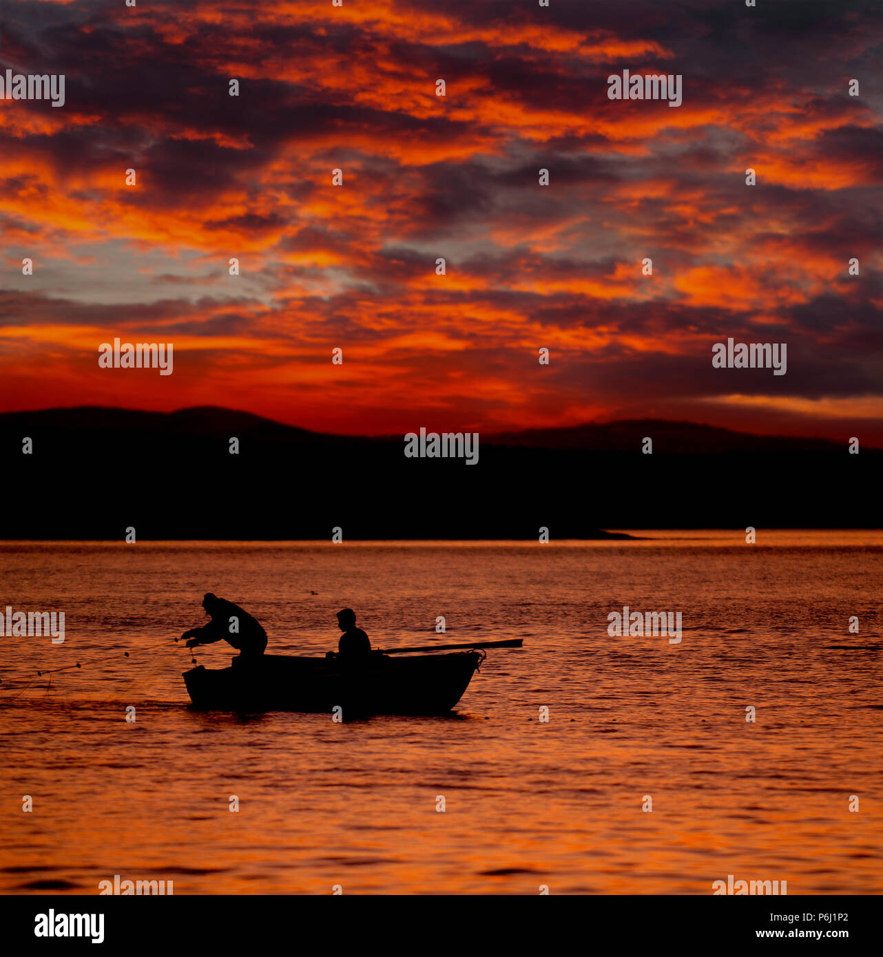Silhouette fishermen at sunset Stock Photo - Alamy