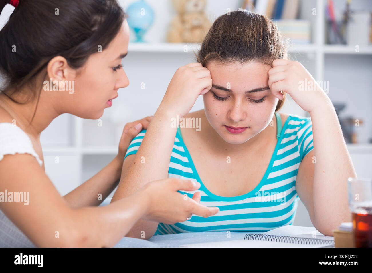Teenage girl calming her chagrined female friend Stock Photo - Alamy