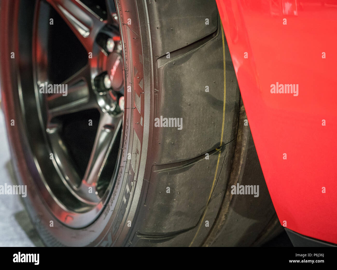 19 May 2018 - London, England. Close up of  Nitto NTO5R drag radial tyre  mounted on red American Muscle car - Dodge Challenger SRT. Stock Photo