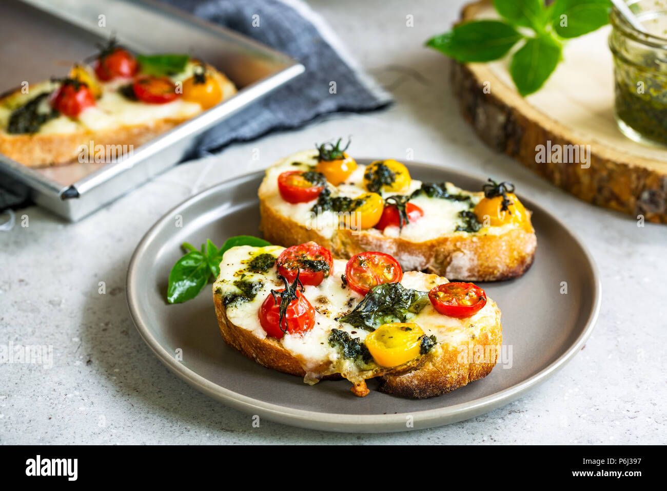 Melt Mozzarella with Cherry Tomatoes and Pesto on toast Stock Photo Alamy