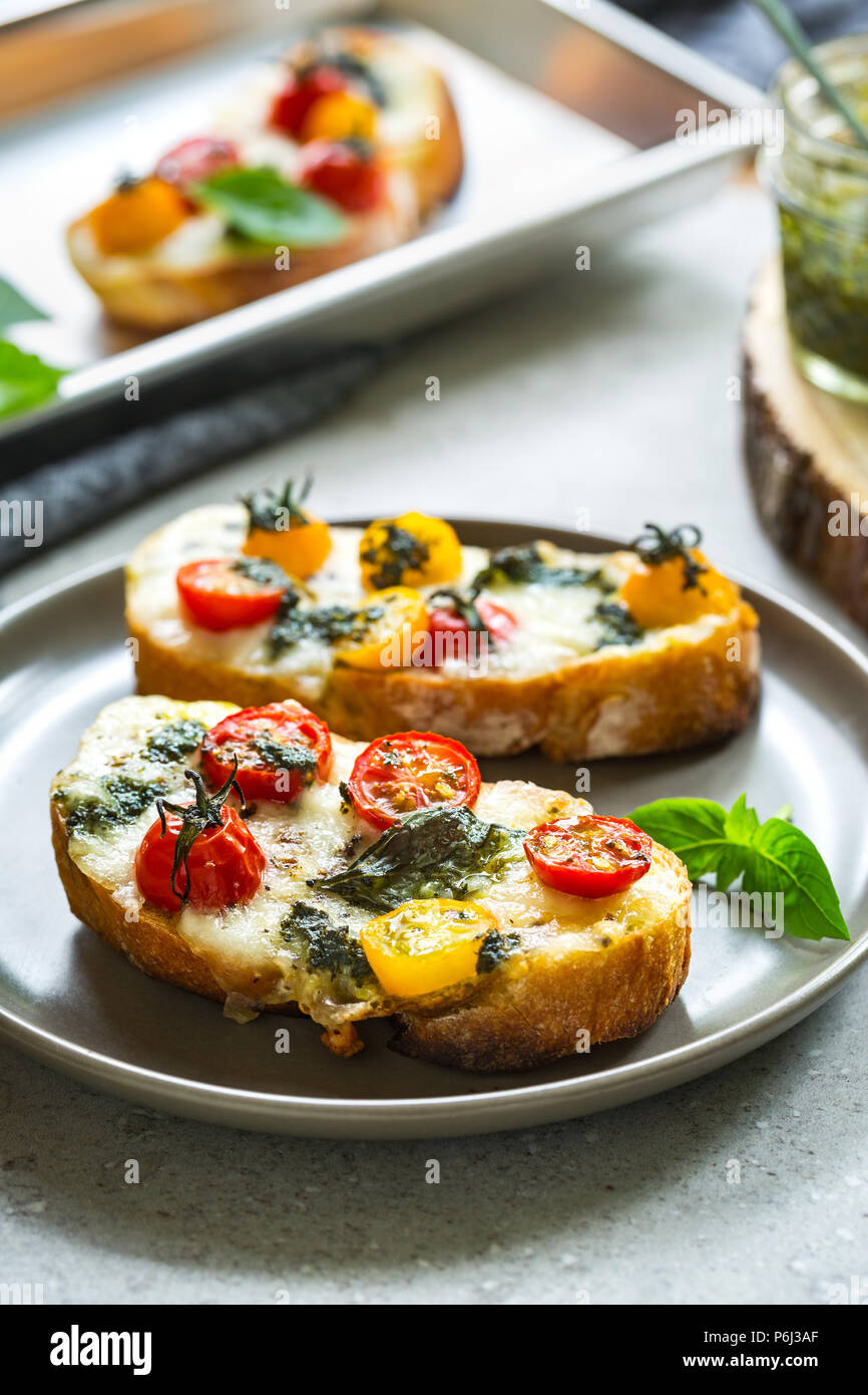 Melt Mozzarella with Cherry Tomatoes and Pesto on toast Stock Photo Alamy