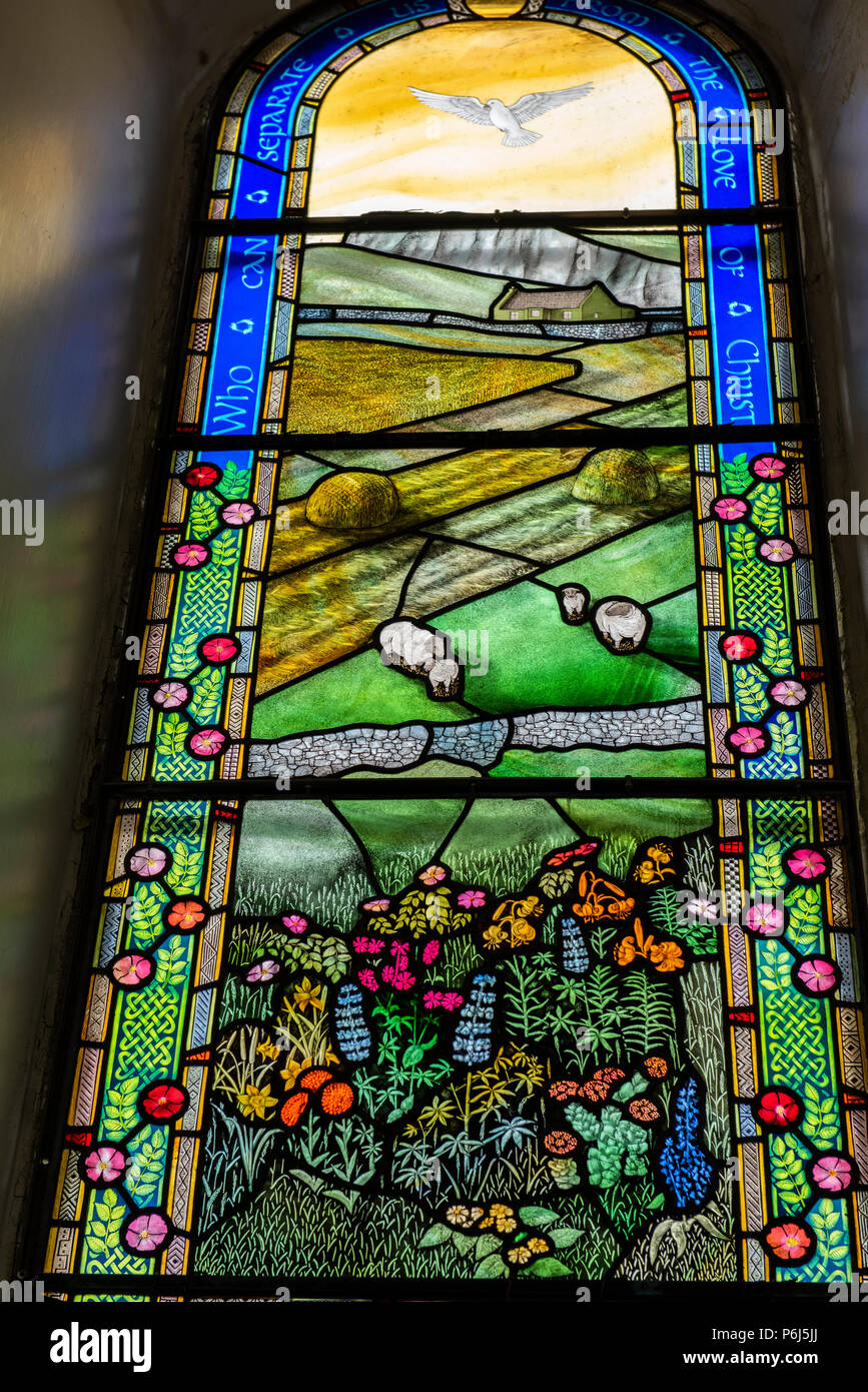 Great Britain, Shetland, Fair Isle. Church of Scotland Kirk, stained glass window. Detail of window depicting countryside, local flora and sheep. Stock Photo