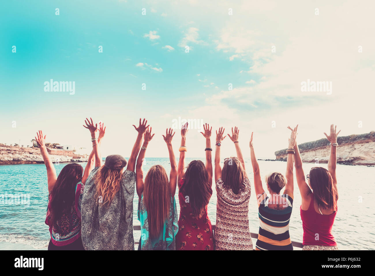 group of women enjoying and celebrate summer vacation all together saying hallo to the ocean and the nature. young people leisure activity, all hands  Stock Photo