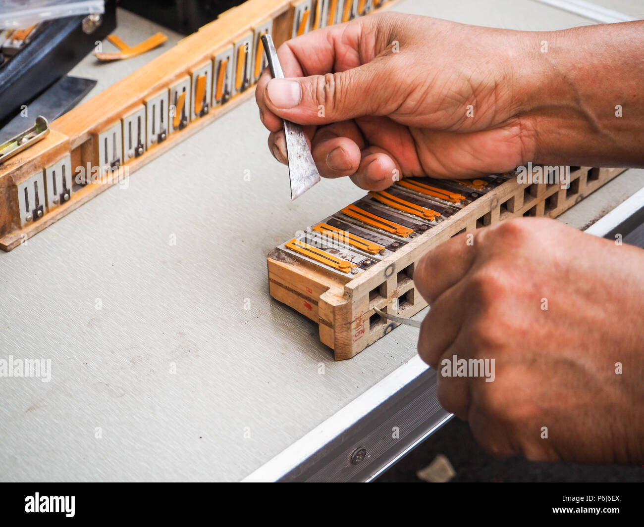 Old man repairing the reed blocks of a vintage accordion, Beijing, China Stock Photo