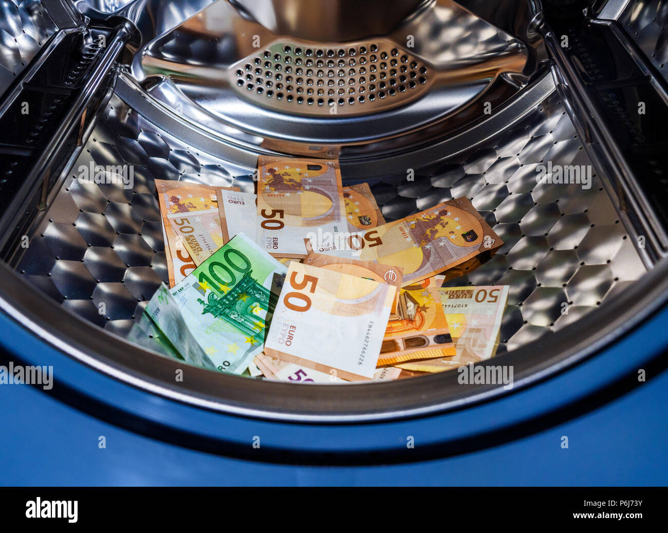 Money laundering symbol, euro banknotes in washing machine with the door open Stock Photo