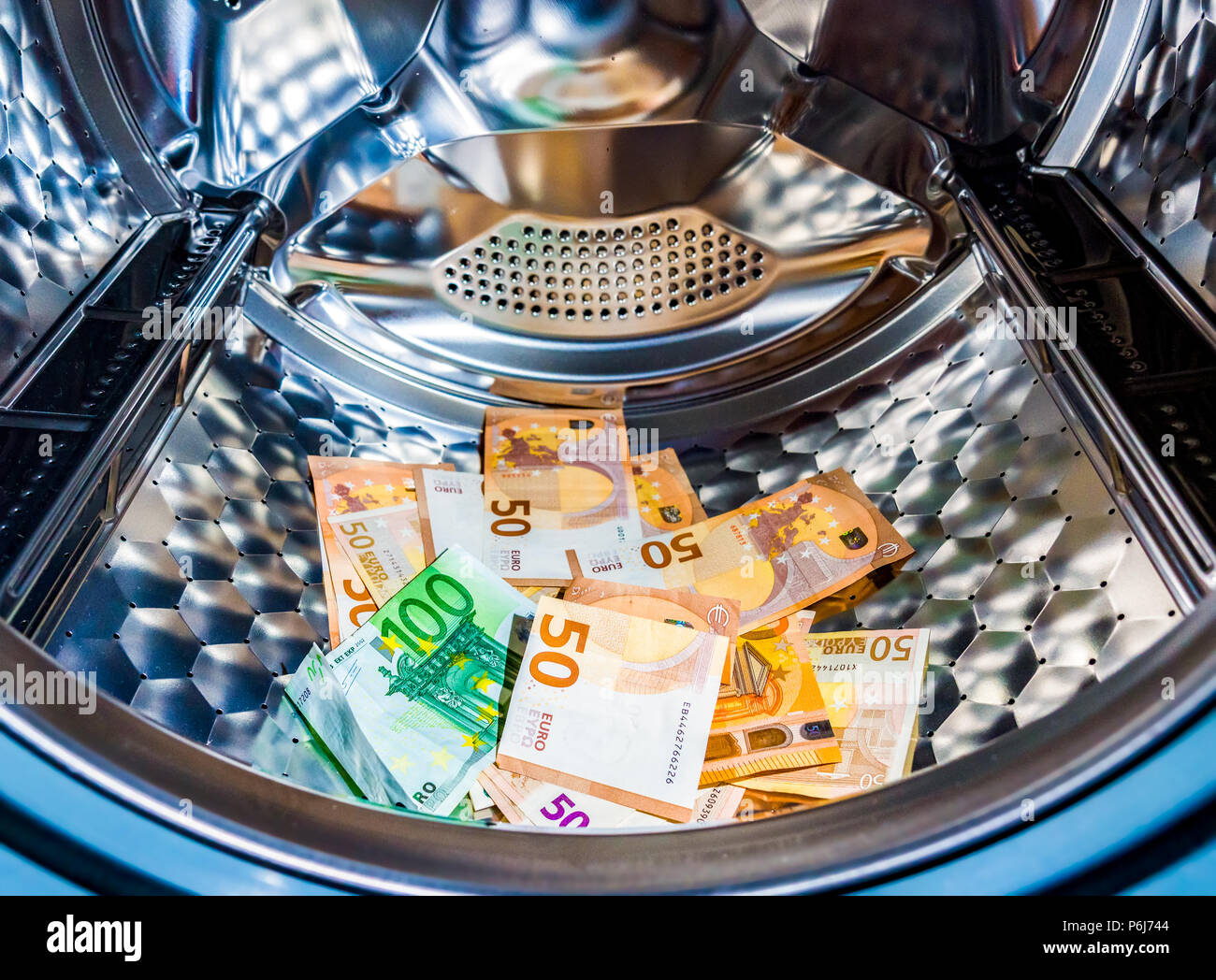 Money laundering symbol, euro banknotes in washing machine with the door open Stock Photo