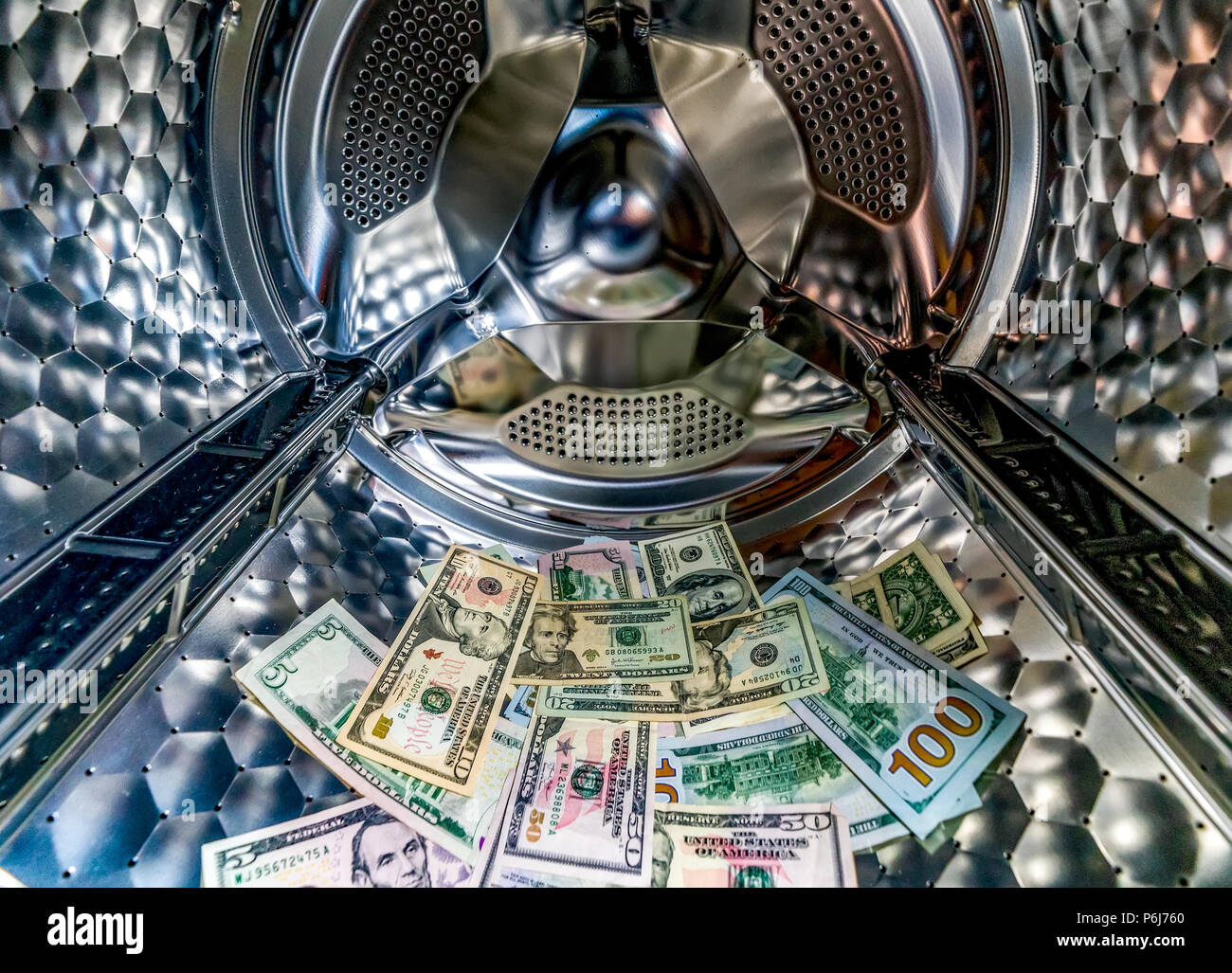 Money laundering symbol, US dollar banknotes in washing machine with the door open Stock Photo