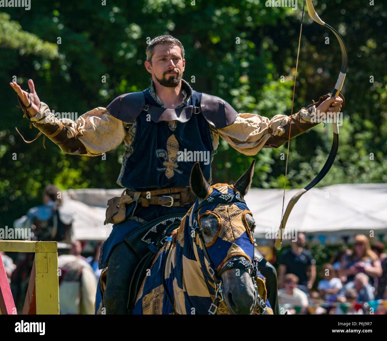 Jousting and Medieval Fair at Linlithgow Palace, Linlithgow, Scotland, United Kingdom, 30th June 2018. Historic Environment Scotland kick off their summer entertainment programme with a fabulous display of Medieval jousting in the grounds of the historic castle. The jousting is performed by Les Amis D'Onno equine stunt team. Knight looks pleased with his archery shot Stock Photo