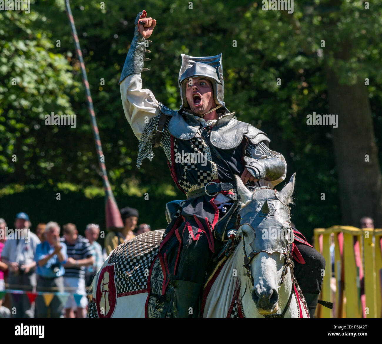 Jousting and Medieval Fair at Linlithgow Palace, Linlithgow, Scotland, United Kingdom, 30th June 2018. Historic Environment Scotland kick off their summer entertainment programme with a fabulous display of Medieval jousting in the grounds of the historic castle. The family fun day includes jousting performed by Les Amis D'Onno equine stunt team. A knight raises his arm and cheers in victory Stock Photo