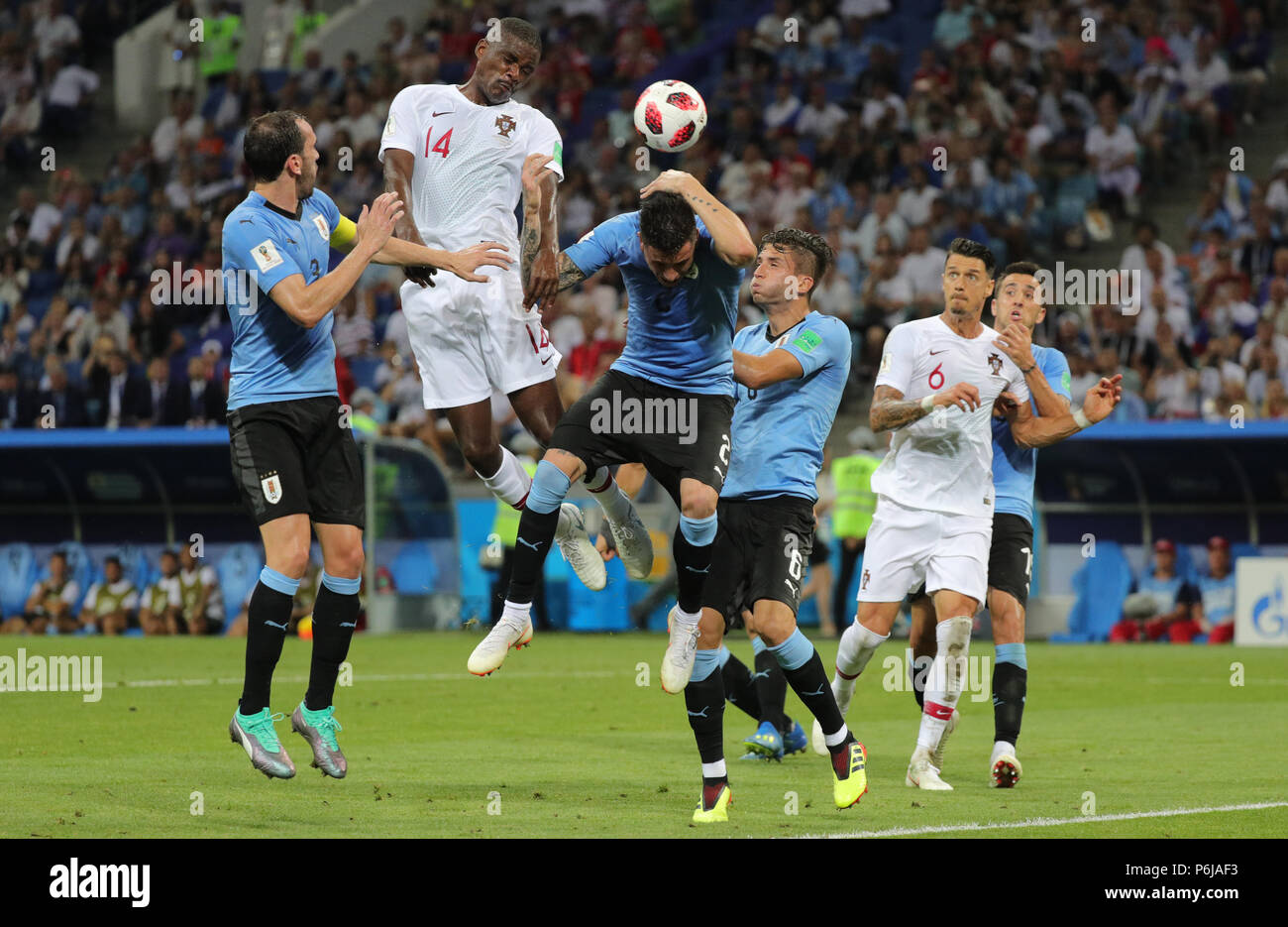 Sochi, Russia. 30th June, 2018. Fußball: Football World Cup, Uruguay vs Portugal at the Fisht Stadium. Jose Maria Gimenez (C) of Uruguay and William Carvalho (top l) of Portugal vie for the ball. Credit: Christian Charisius/dpa/Alamy Live News Stock Photo