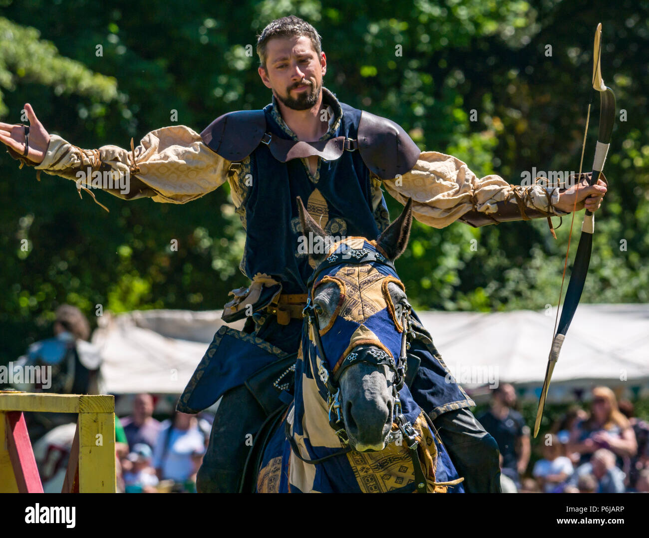 Jousting and Medieval Fair at Linlithgow Palace, Linlithgow, Scotland, United Kingdom, 30th June 2018. Historic Environment Scotland kick off their summer entertainment programme with a fabulous display of Medieval jousting in the grounds of the historic castle. The jousting is performed by Les Amis D'Onno equine stunt team. A knight looks pleased with his archery shot Stock Photo