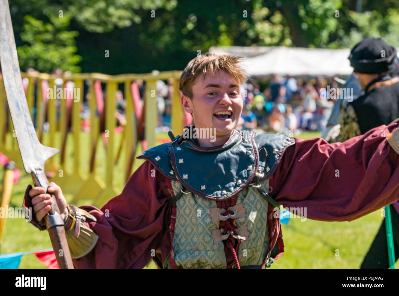 Jousting and Medieval Fair at Linlithgow Palace, Linlithgow, Scotland, United Kingdom, 30th June 2018. Historic Environment Scotland kick off their summer entertainment programme with a fabulous display of Medieval jousting in the grounds of the historic castle. The jousting is performed by Les Amis D'Onno equine stunt team based in the Borders. A knight smiles and raises his sword Stock Photo