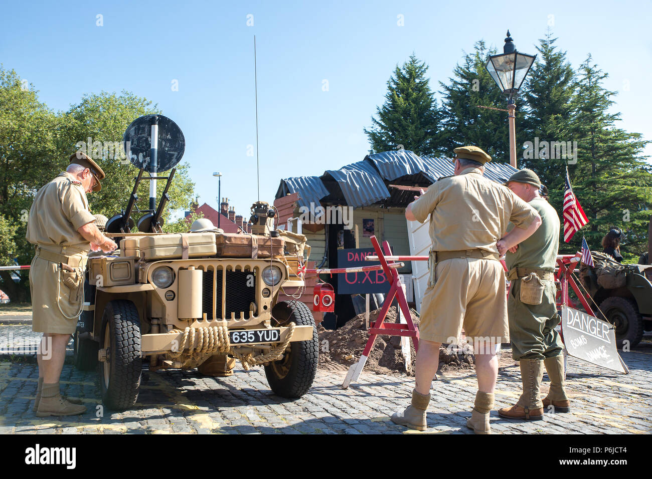 Kidderminster, UK. 30th June, 2018. AA journey back in time begins on the Severn Valley Railway as we turn the clock back to the 1940s. Visitors and staff pull out all the stops to ensure a realistic wartime Britain is experienced on this heritage railway line. Here an American 1943 Willy's MB jeep (in desert sand colour) is being closely inspected amongst other military light utility vehicles on display outside the Kidderminster vintage train station. Credit: Lee Hudson/Alamy Live News Stock Photo