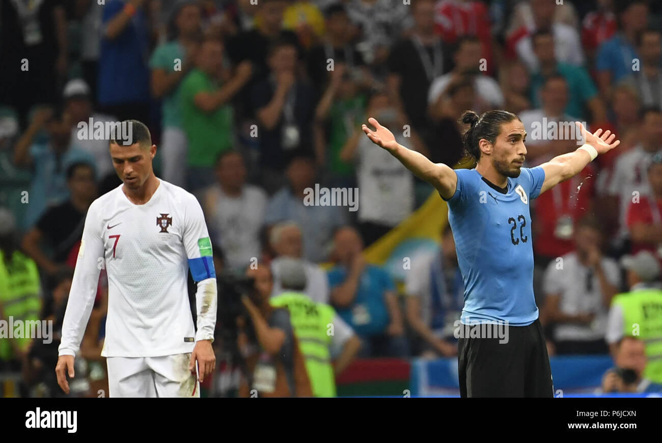 Sochi, Russia. 30th June, 2018. Cristiano Ronaldo (L) of Portugal looks depressed as Martin Caceres of Uruguay celebrates victory after the 2018 FIFA World Cup round of 16 match between Uruguay and Portugal in Sochi, Russia, on June 30, 2018. Uruguay won 2-1 and advanced to the quarter-final. Credit: Chen Cheng/Xinhua/Alamy Live News Stock Photo