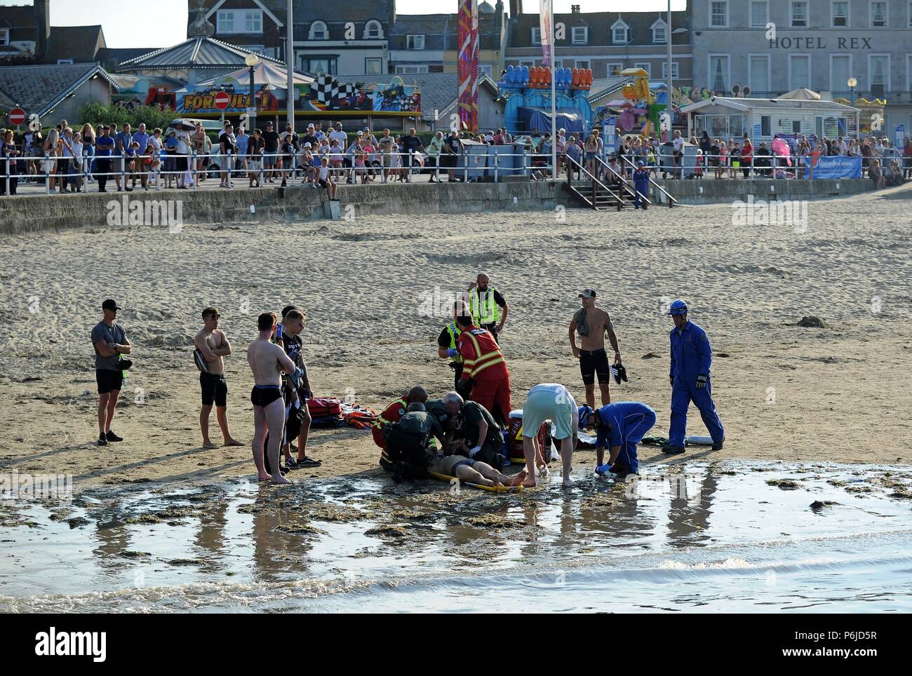 Weymouth beach, Dorset, UK. 30th Jun, 2018. An injured man is stretchered onto an air ambulance after an incident on Weymouth beach Credit: Finnbarr Webster/Alamy Live News Stock Photo