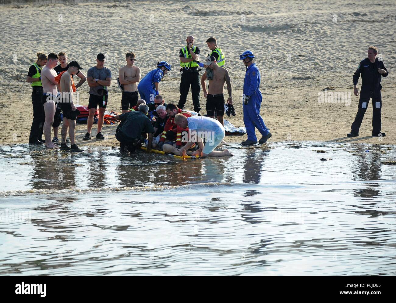 Weymouth beach, Dorset, UK. 30th Jun, 2018. An injured man is stretchered onto an air ambulance after an incident on Weymouth beach Credit: Finnbarr Webster/Alamy Live News Stock Photo