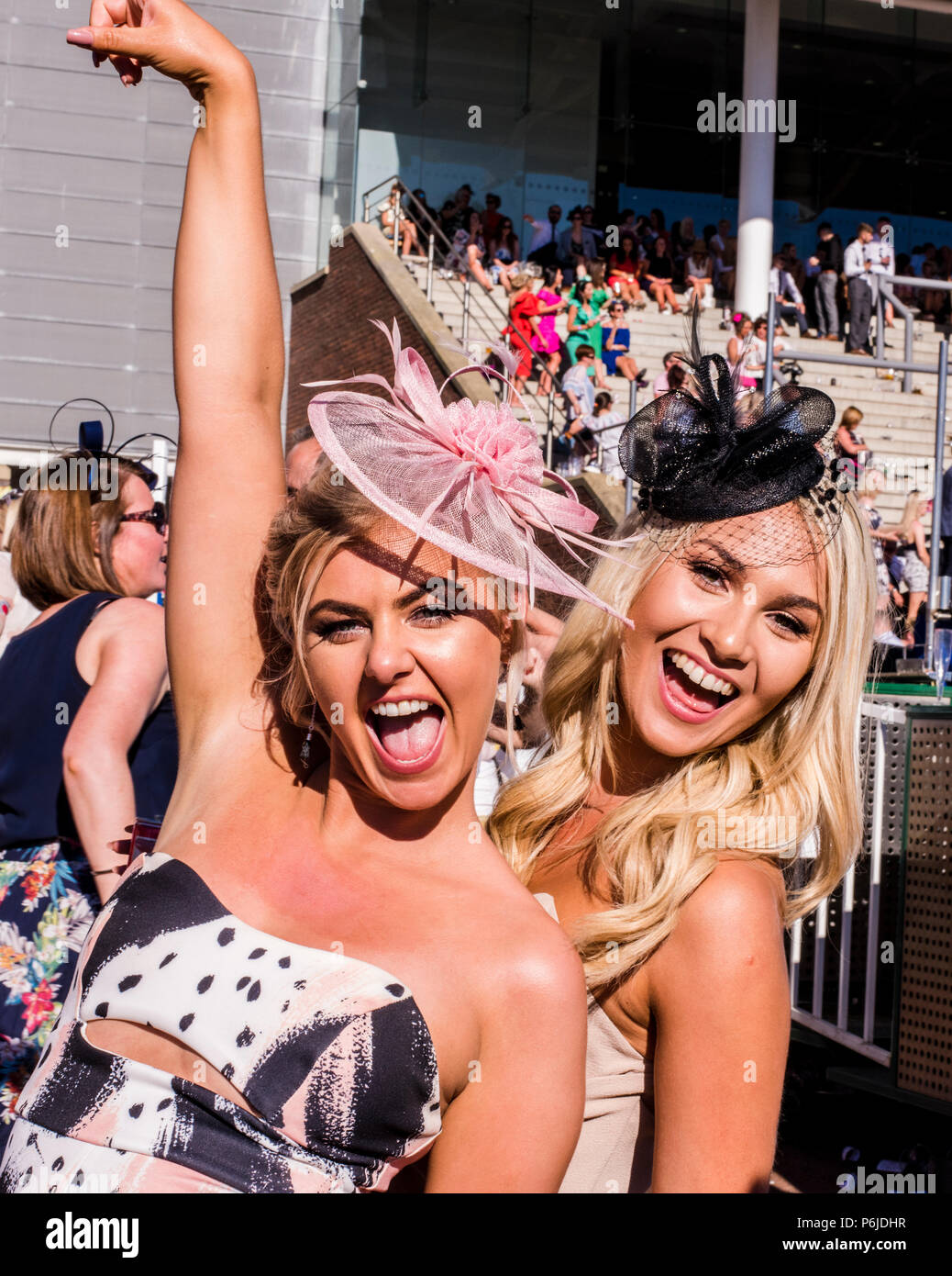Two young female racegoers, dancing and posing for the camera during Paloma Faith's performance at York Racecourse, York, England, 30th June 2018 Stock Photo