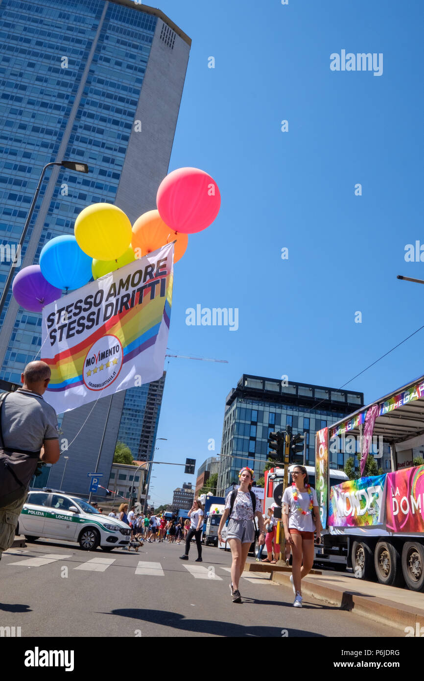Milan, Italy. 30th Jun, 2018. Milano Pride 2018, manifestation of gay, lesbians, asexuals, bisexuals, intersexual and queer pride. A man holding colored ballons and a banner before the start of the parade. Milan, Italy. June 30, 2018. Credit: Gentian Polovina/Alamy Live News Stock Photo