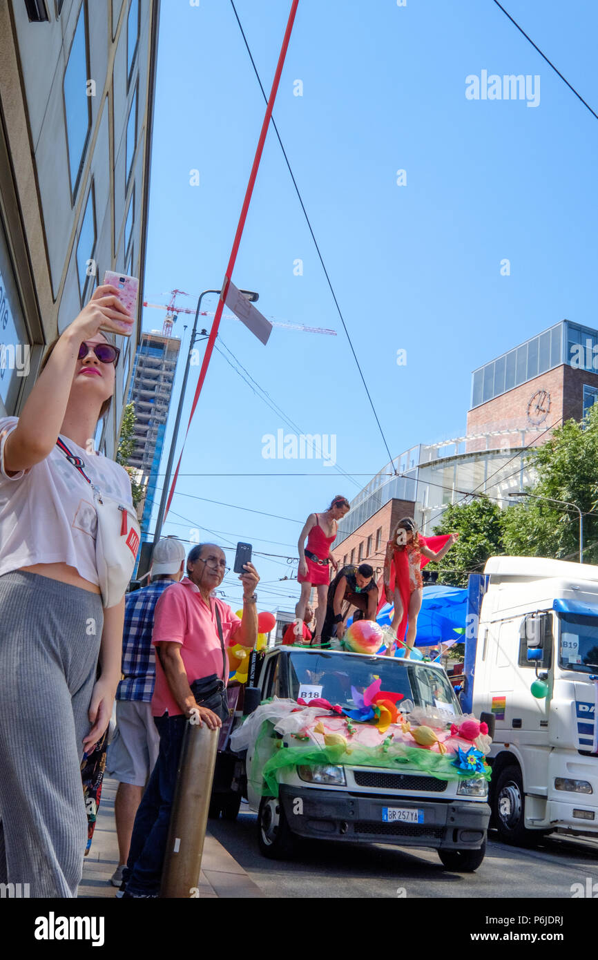 Milan, Italy. 30th Jun, 2018. Milano Pride 2018, manifestation of gay, lesbians, asexuals, bisexuals, intersexual and queer pride. Young woman and a man taking selfies during the parade. Milan, Italy. June 30, 2018. Credit: Gentian Polovina/Alamy Live News Stock Photo